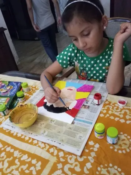 Concentration and creativity in action. Here, a student carefully paints a portrait inspired by famous artists, learning about color blocking and composition in a fun, hands-on way.