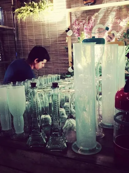 Preparing for a molecular bar service. The setup includes specialized glassware like Eiffel Tower bottles and graduated cylinders, turning the bar into a veritable science lab.
