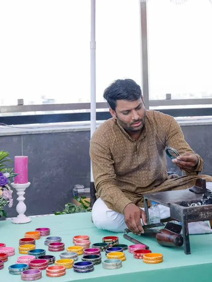 A live lac bangle maker at the mehendi, a wonderful interactive element that gives guests a personalized and traditional favor to take home.