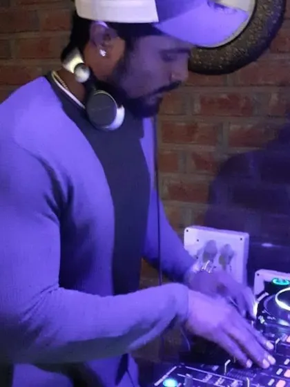 A profile shot of me mixing in a venue with a cool brick wall background.