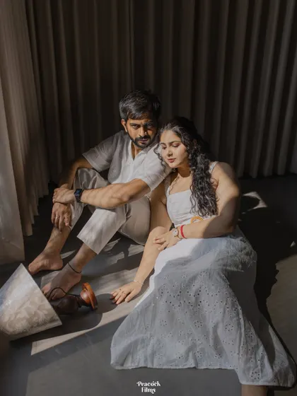 A quiet, artistic portrait of a couple sitting in the soft sunlight. This pre-wedding shot uses shadows and light to create a beautifully intimate and contemplative mood.