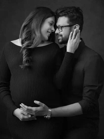 A black and white version of a tender moment, focusing on the couple's loving gaze. This edit brings a classic, cinematic feel to their maternity photoshoot.