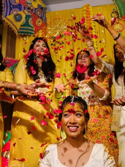 The bride's friends shower her with rose petals during the haldi, creating a beautiful and colourful memory.
