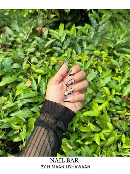 A client posing with her new nails outdoors, showing how great they look in natural light.