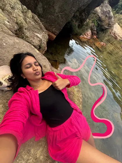 Chilling by a natural pool in Meghalaya. The pink doodle adds a pop of color to the serene scene.