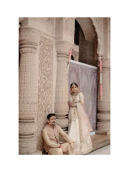 A regal portrait of the couple within the temple, the intricate architecture framing them perfectly.
