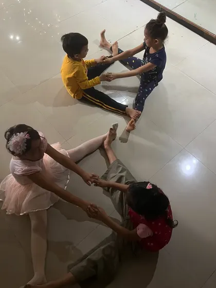 Students practice a partnered stretching exercise, working together to improve their flexibility.