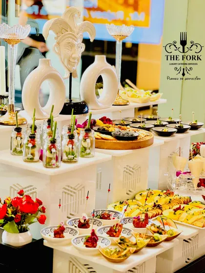 My approach to designer catering is about creating a complete sensory experience. This buffet setup features multi-level displays, artistic decor elements, and a vibrant array of appetizers, ensuring the food presentation is as impressive as the taste.