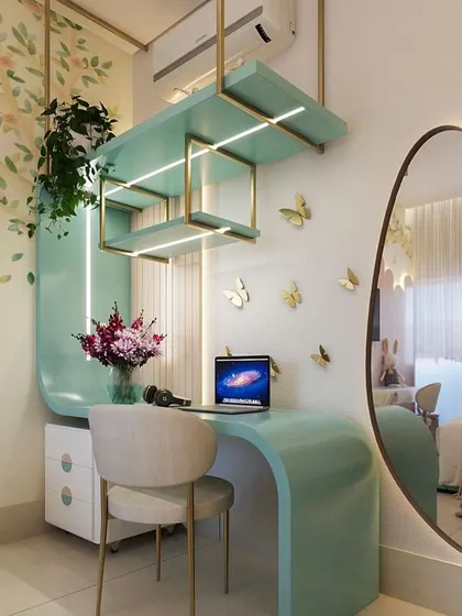 A whimsical and elegant study corner design. The curved mint-green desk, suspended shelving with gold accents, and butterfly wall decor create a magical and inspiring workspace.