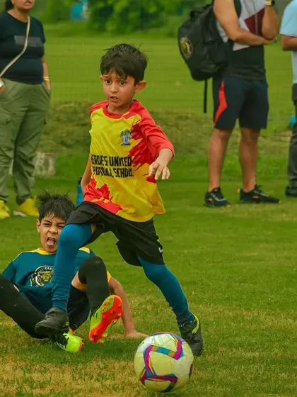 A player navigates past a sliding tackle from an opponent.