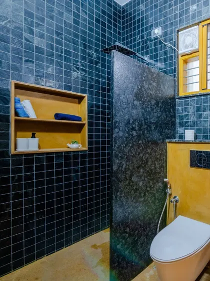 A granite partition separates the wet and dry areas in the bathroom, which also features a built-in wooden niche for storage.