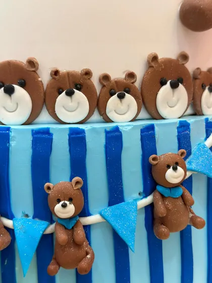 A close-up of the tiny fondant teddy bears on the side of the three-tiered cake, each with its own little scarf.