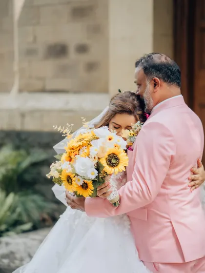 The groom's reaction says it all. This emotional first look, with the bride holding a bouquet of sunflowers, is a moment of pure love and surprise.