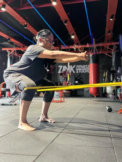 Even in a studio setting, the principles of good form apply. This resistance band squat helps reinforce proper posture and engagement, skills we work on in our online sessions.
