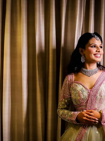 A portrait of a woman smiling, taken in a hotel room with soft, warm lighting.