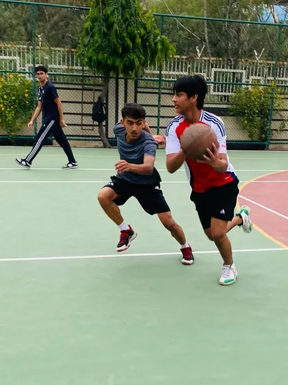 A player protects the ball while driving against a defender, a key skill for guards.