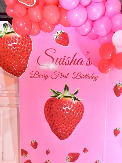 A close-up of the strawberry-themed backdrop, personalized for the birthday girl.