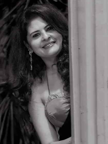 A black and white portrait capturing a soft, smiling expression in a modern-draped saree.