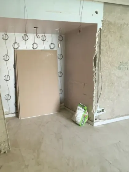 The unfinished corner shows exposed wiring and wall preparation before our backlit pooja unit was installed in this space.