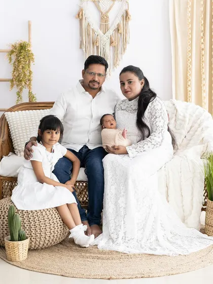 A complete family portrait after the arrival of the new baby. The all-white outfits create a clean, classic look in our cozy boho studio.