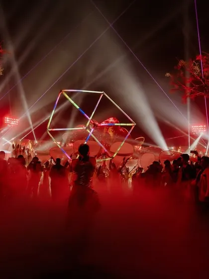 The entire party is bathed in red light as performers with LED props entertain the guests, turning the celebration into a visual masterpiece.
