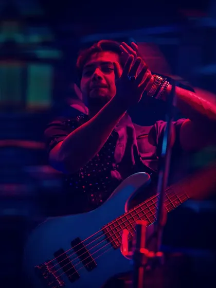 The bassist feeling the groove under the vibrant stage lights. Our performances are a visual and auditory treat, perfect for high-end events.
