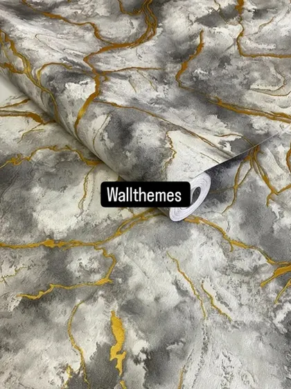 A close-up of a grey and white marble-effect wallpaper with rich gold veining.