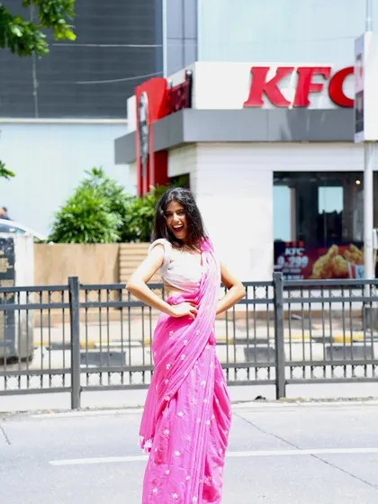 A fun and quirky shot in a pink saree outside a KFC, showcasing my relatable personality and ability to create unconventional, eye-catching content.