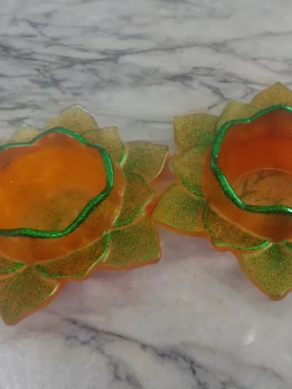 A pair of bright and cheerful lotus T-light holders. The warm orange and yellow tones with a touch of green on the edges are perfect for adding a pop of color to your mandir or home.