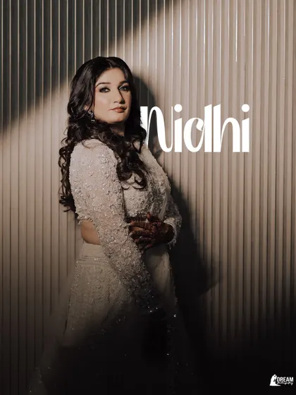 A stylish portrait of bride Nidhi, with dramatic lighting creating a beautiful play of light and shadow on her and her sequined outfit.