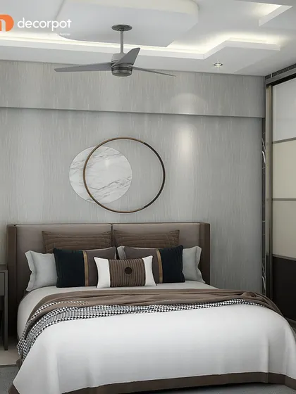 A serene and modern bedroom design featuring a neutral color palette. The circular wall art above the bed adds a point of interest, while the simple furnishings create a calm and uncluttered environment.
