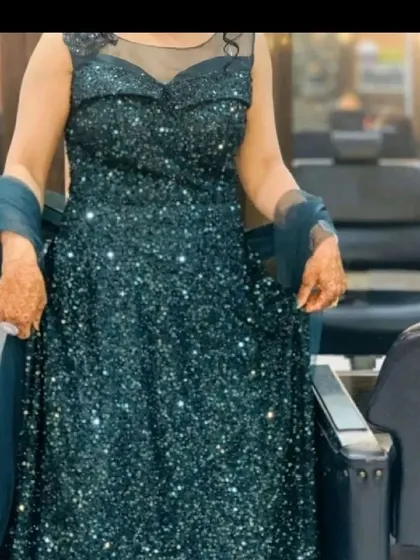 A client trying on our green sequined gown. This dress is perfect for making a sparkling statement at any event.