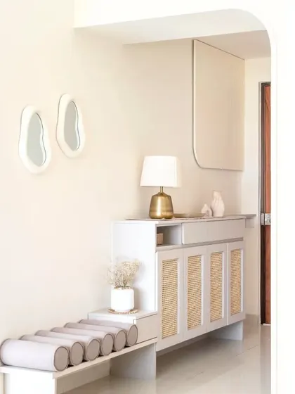 A bohemian-inspired foyer unit that makes a great first impression. It features wicker accents for texture, curved cushions for seating, and open units for convenient storage.