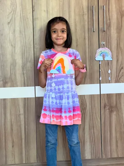 This girl's colorful tie-dye shirt perfectly matches the rainbow craft she made. So much color and joy.