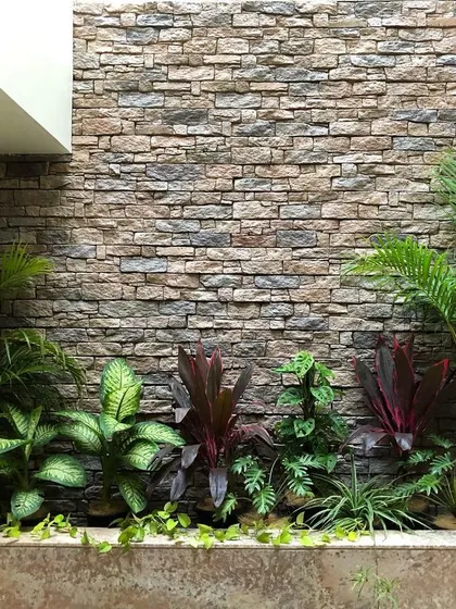This planter is in a basement, receiving light only from a skylight above. We solved this low light challenge by choosing sturdy indoor plants like Dieffenbachia and indoor palms, using their vibrant foliage to bring life and color to a space where flowers might not thrive.