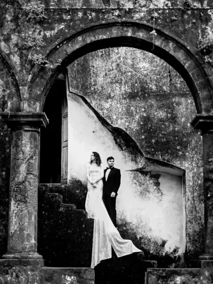 A black and white portrait emphasizing the stunning architecture and the elegant silhouette of the couple. The arches create a beautiful natural frame.