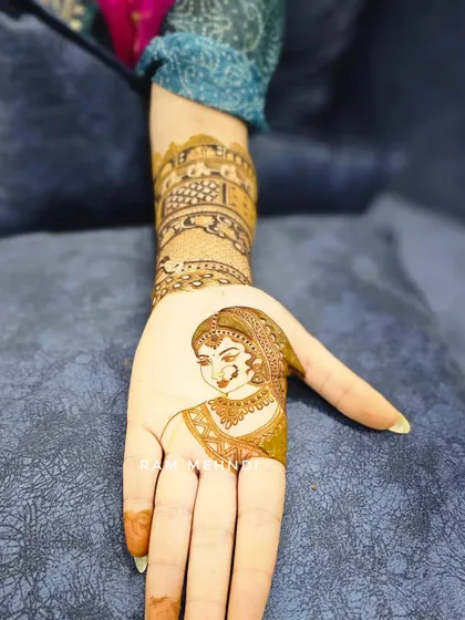 A single bride portrait on the palm, paired with an architectural design on the arm. This shows how we can mix different styles to create a cohesive and personal bridal mehndi.