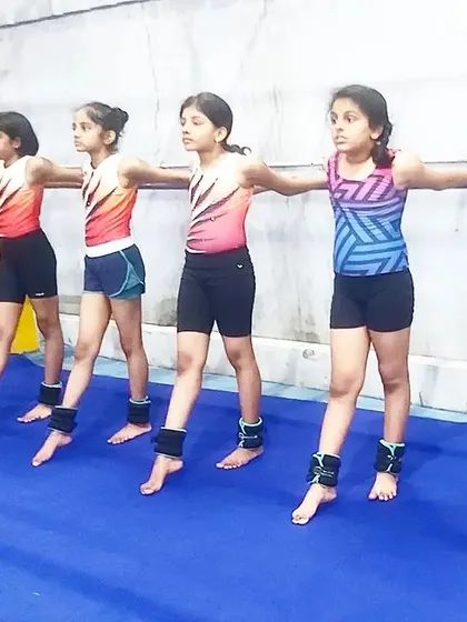 Every session starts with conditioning to build a strong foundation. Here, my students work on their posture and strength with ankle weights, a key part of our gymnastics fitness program.