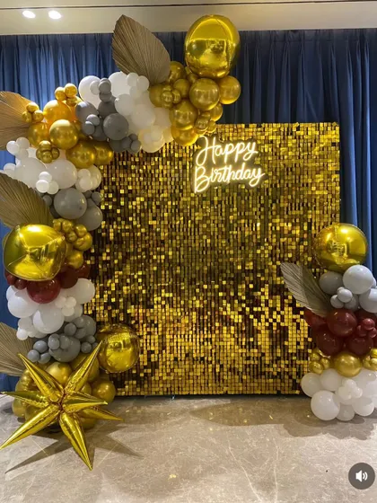 A wider shot of the gold sequin backdrop, showing the full scale of the balloon decoration. The arrangement elegantly frames the shimmer wall, making it an impressive centerpiece for a milestone birthday or a glamorous bachelorette party.
