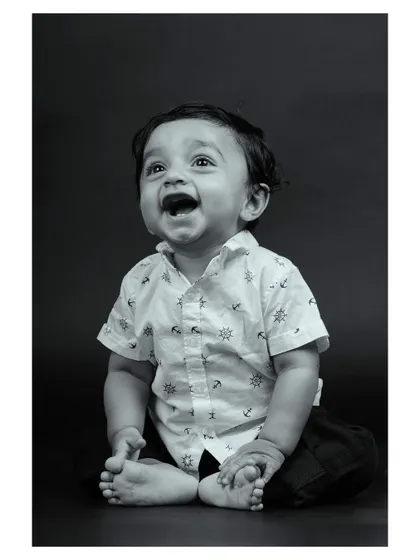 A baby's joyful laugh captured in a black and white studio portrait. This image is pure happiness, emphasized by the simple monochrome palette.