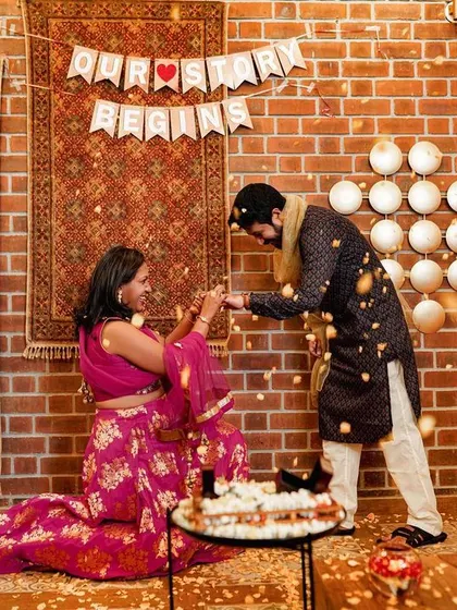 A surprise proposal moment during an engagement party, with confetti falling as she says yes.