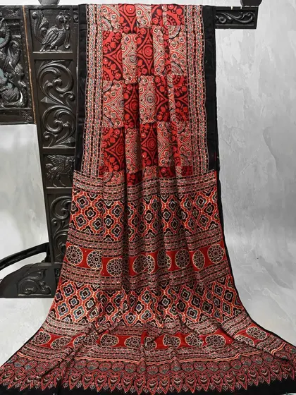 A striking red and black block-printed saree with intricate geometric patterns. This is a bold and artistic piece that is sure to make a statement.