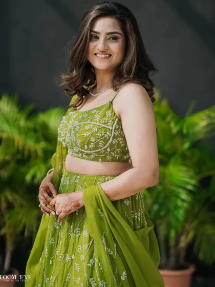 A candid portrait of a woman in a lovely green lehenga, perfect for a Mehendi or Sangeet event.