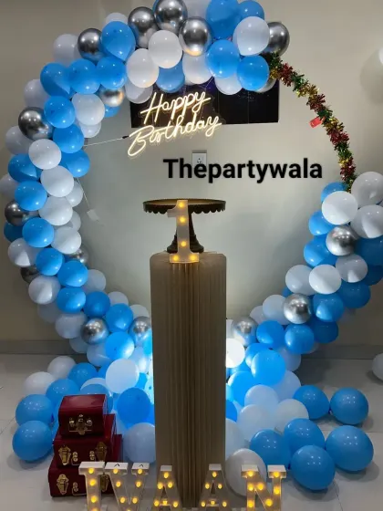 A simple blue and white balloon ring with a single pedestal for the cake.