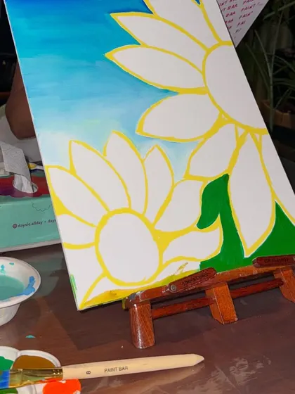 A sunflower painting in progress at a birthday celebration. We love seeing guests get lost in the creative process, adding their own personal touches to their artwork.