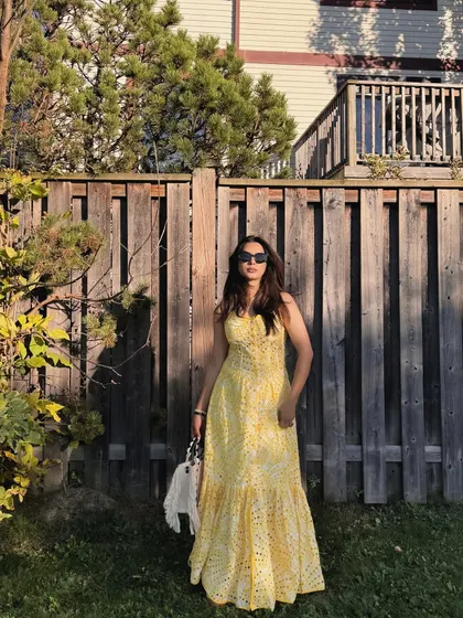 A complete look at the Jardinvue summer outfit against a rustic wooden fence.