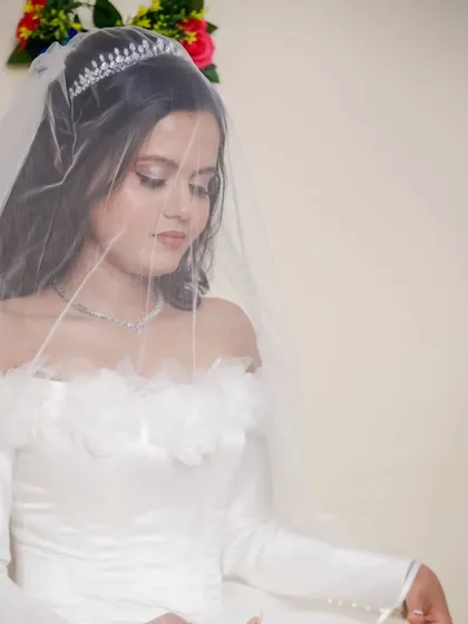 A soft and dreamy portrait of the bride under her veil. The off-shoulder satin gown and delicate tiara give her a classic, fairytale princess look.