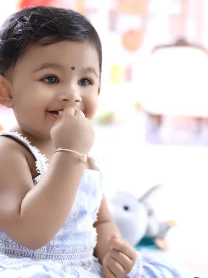 A candid, happy moment from a first birthday session. This little girl's bright smile shows how much fun our photoshoots can be.