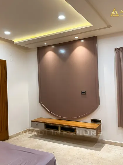 The TV unit in the mauve bedroom, featuring a floating console and a curved back panel that mirrors the arch of the headboard, ensuring design consistency.