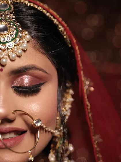 A half-face portrait focusing on the stunning rose-gold shimmer eye makeup and the perfectly winged liner.